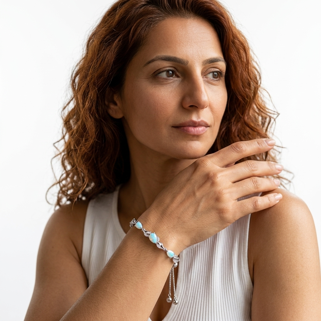 Woman wearing the white opal bracelet on her wrist while resting her hand near her shoulder.