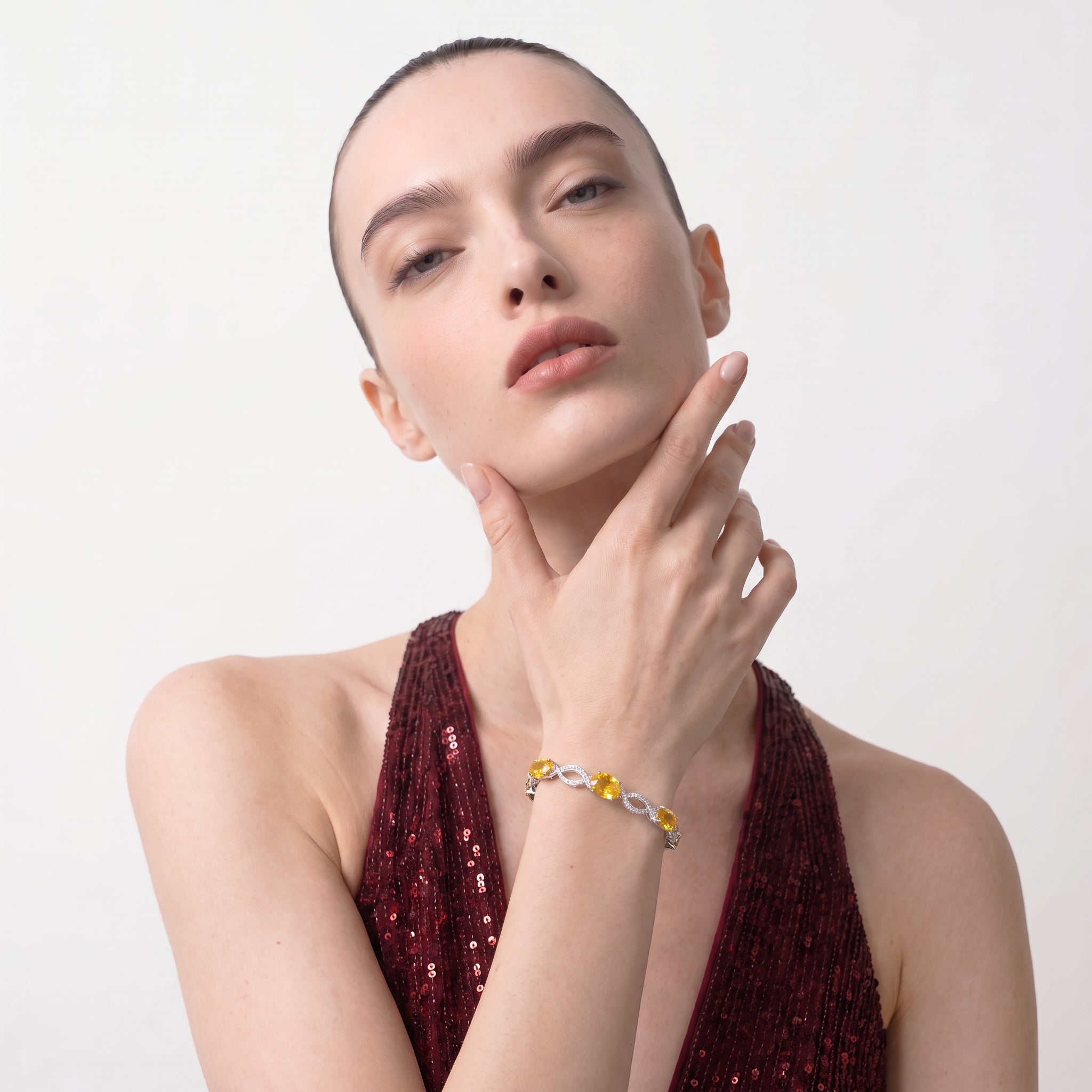 Close-up of a woman wearing the citrine bracelet with her hand resting near her shoulder.