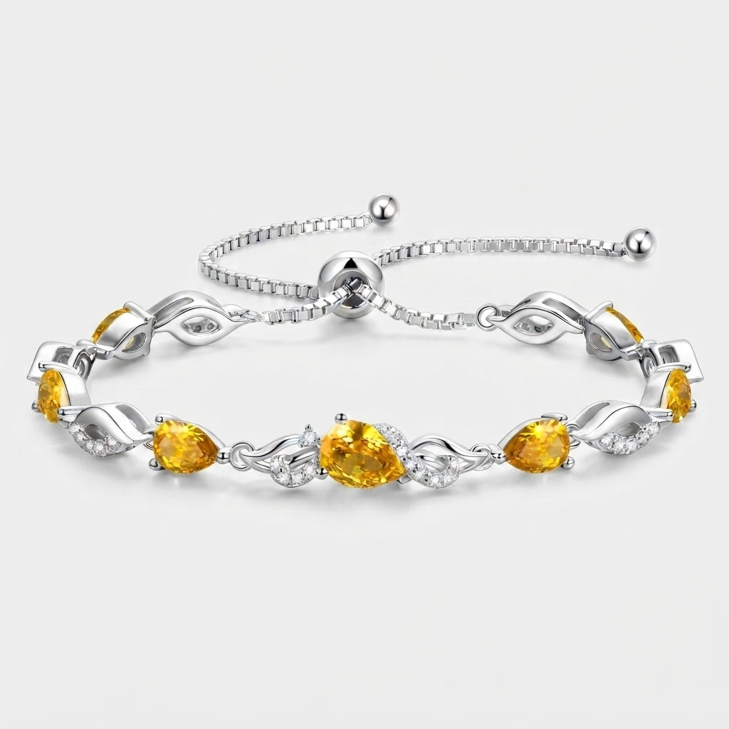 Citrine teardrop tennis bracelet in sterling silver laid flat, showing the adjustable bolo clasp and leaf-link design.