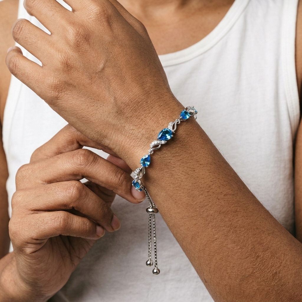 Close-up of the blue topaz tennis bracelet worn on a wrist, showing the deep blue teardrop stones and CZ accents.