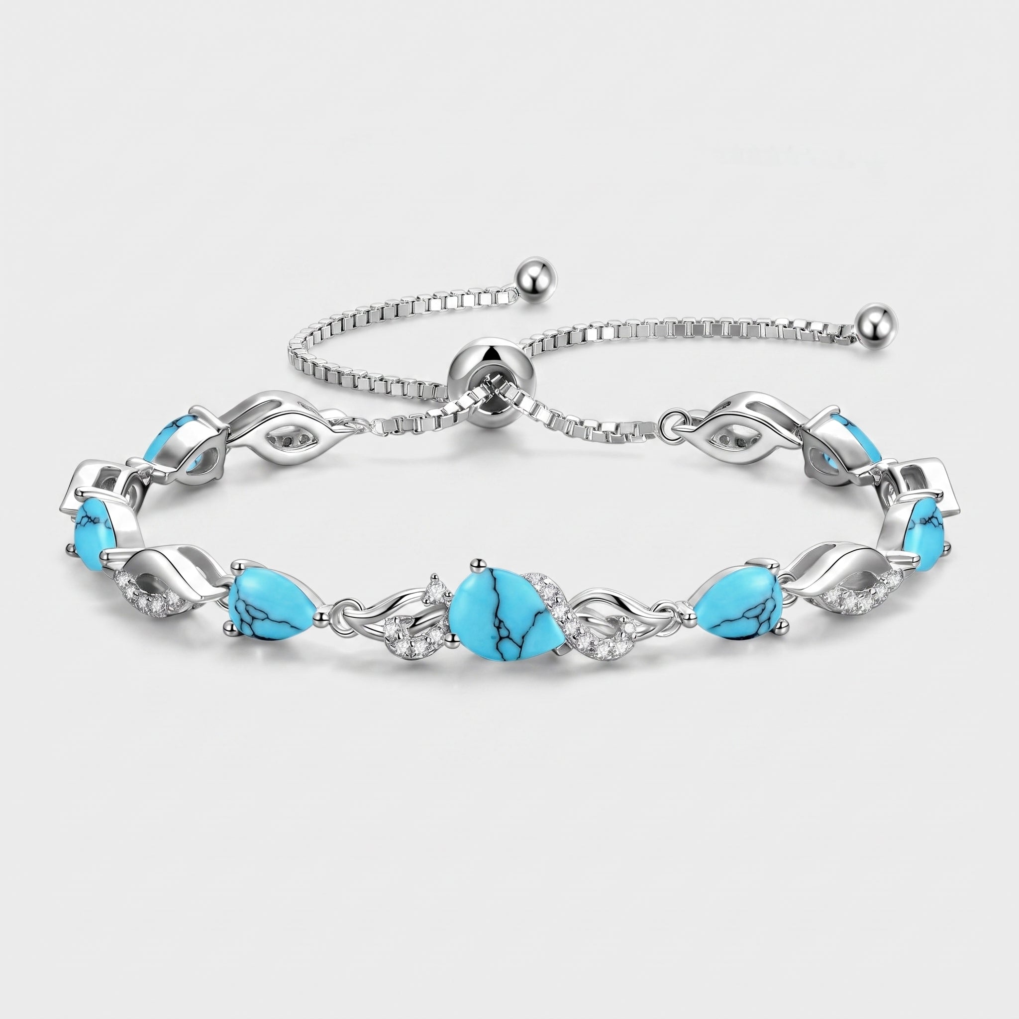 Turquoise teardrop tennis bracelet in sterling silver laid flat, showing the adjustable bolo clasp and leaf-link design.