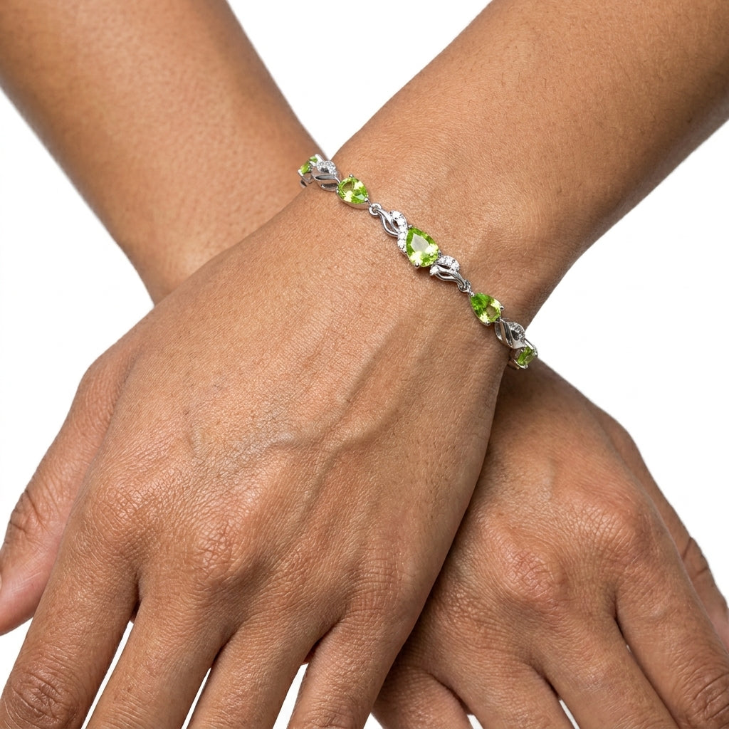 Close-up of the peridot bracelet worn on a wrist, showing the sparkle of each stone.