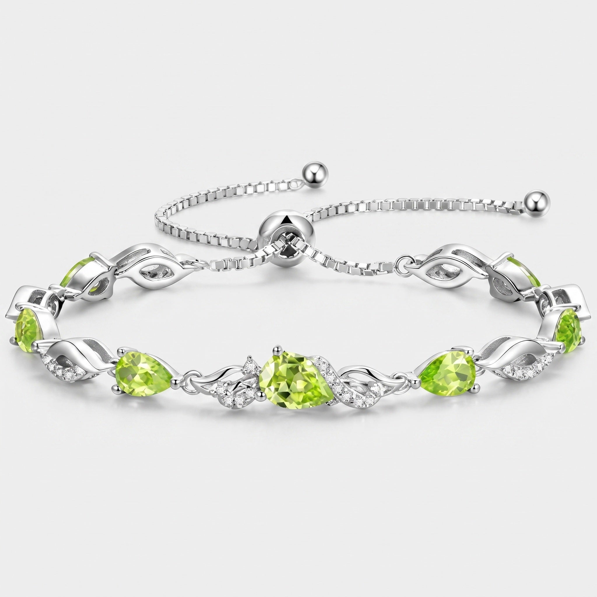 Peridot teardrop tennis bracelet in sterling silver laid flat, showing the adjustable bolo clasp and leaf-link design.