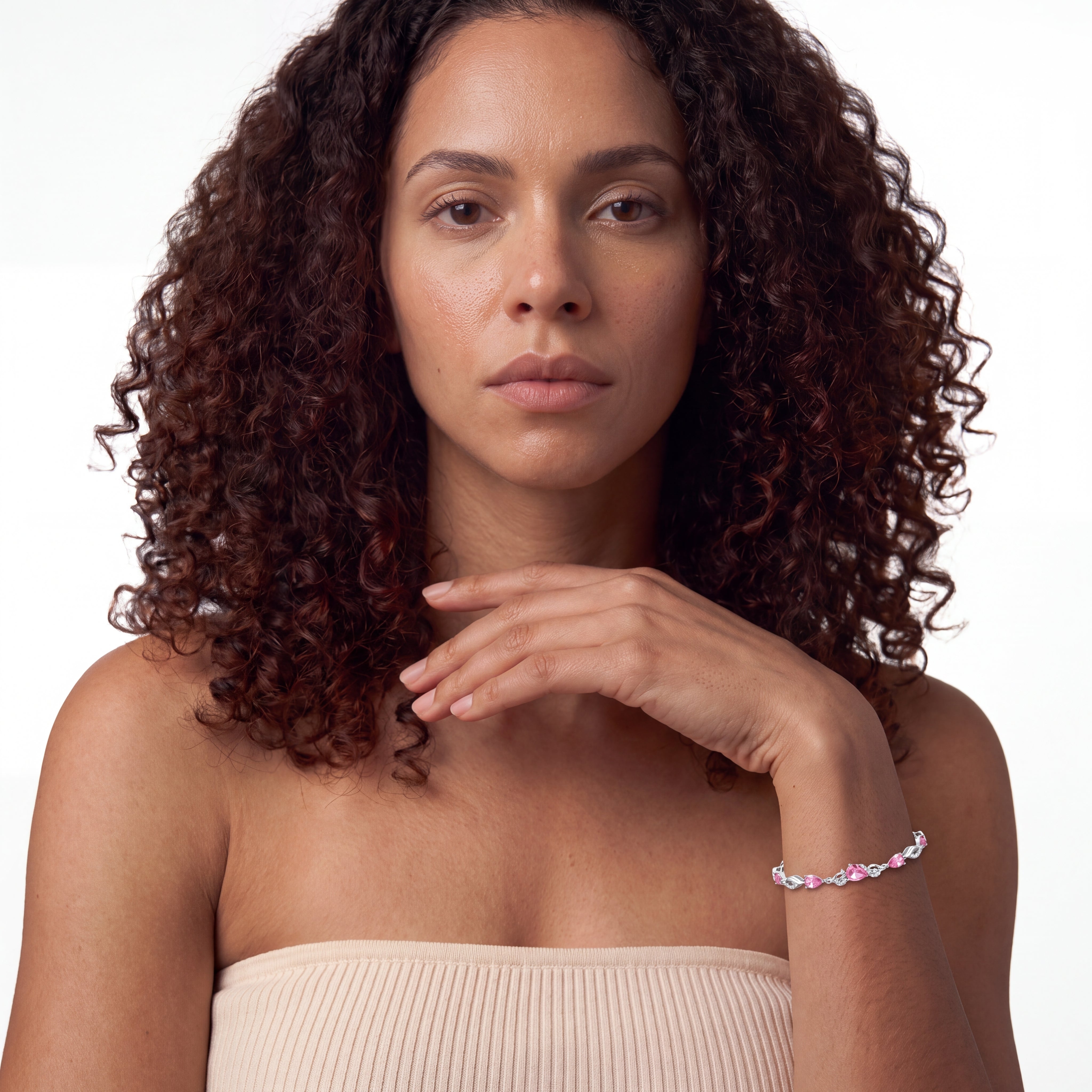 Woman wearing pink tourmaline tennis bracelet on her wrist near her collarbone