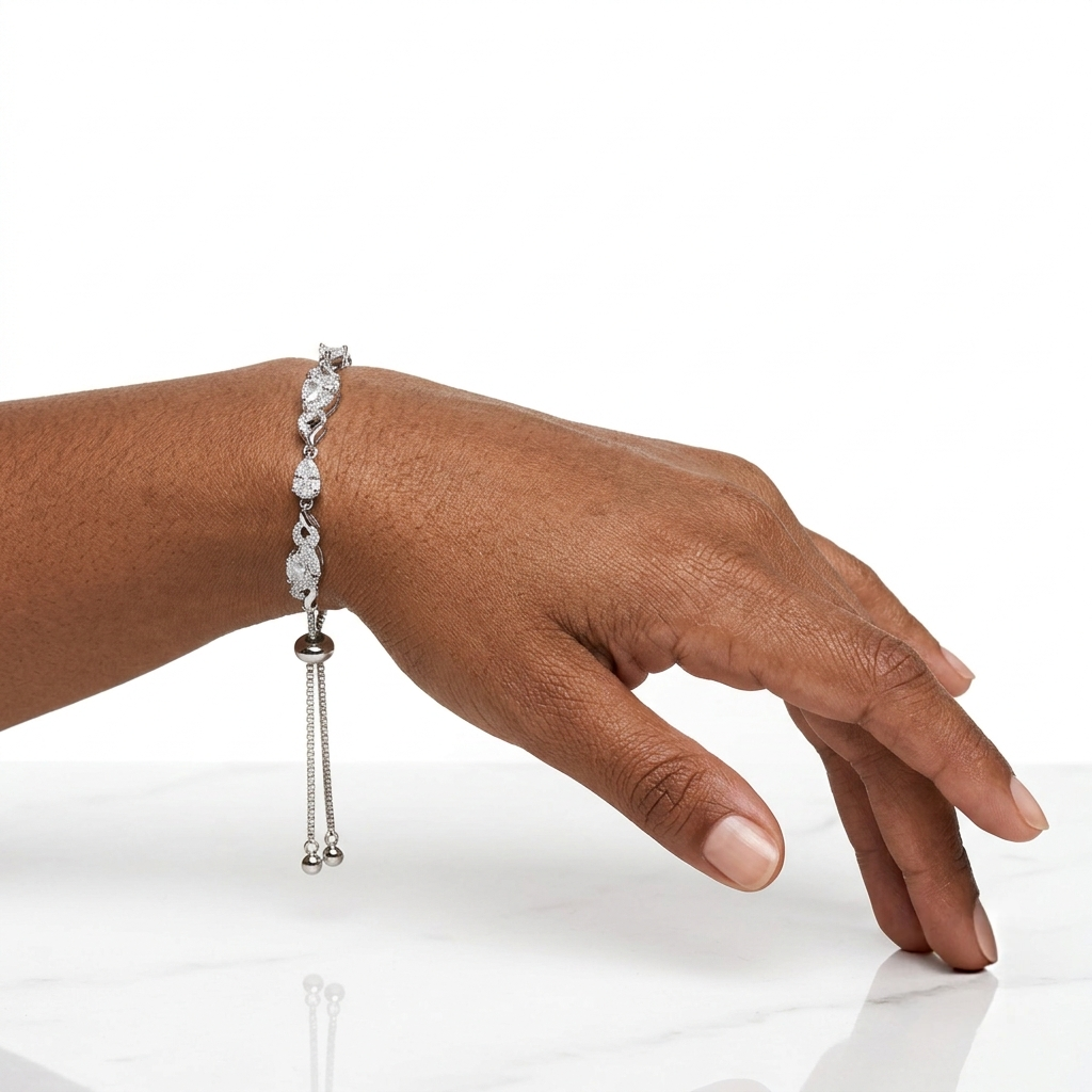 Woman's wrist wearing CZ tennis bracelet, hand resting on marble surface