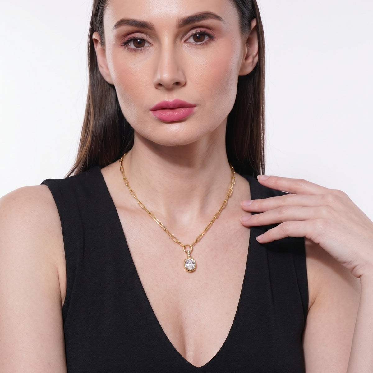 Woman wearing an 18K gold plated oval solitaire necklace with a V-neck black top