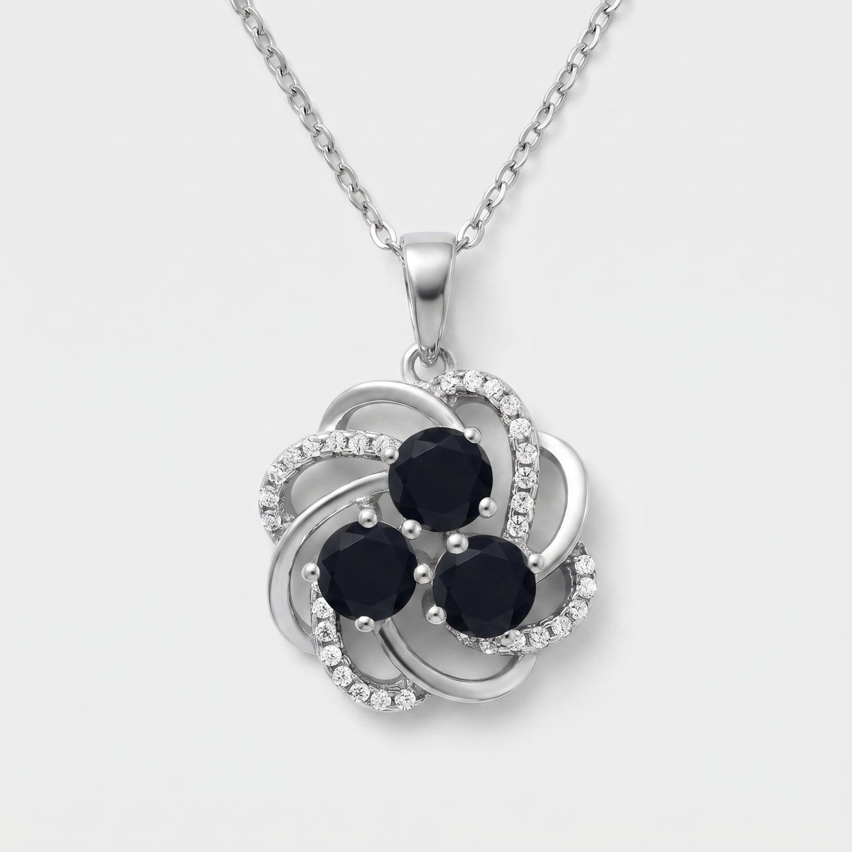 Sterling silver flower pendant with three round black onyx stones and white CZ swirl accents