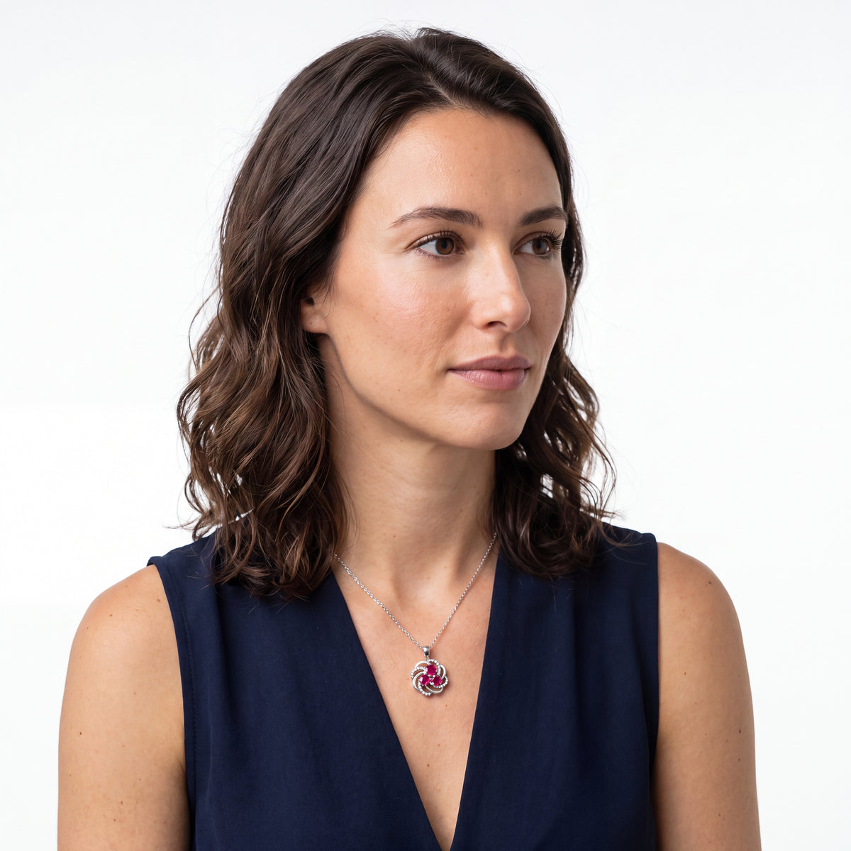 Woman in a navy dress wearing a created ruby and silver flower necklace