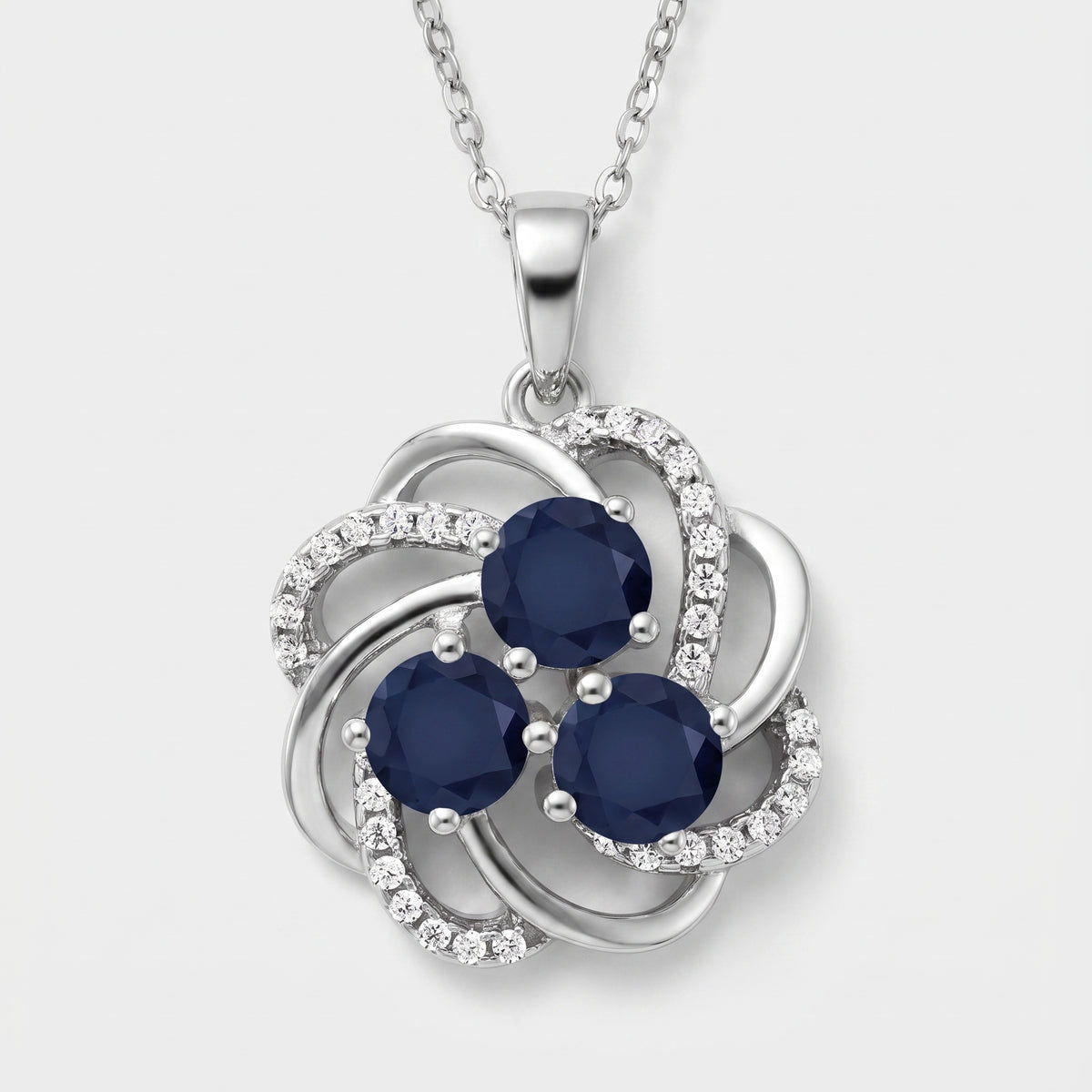 Sterling silver blossom pendant with three round blue sapphires and white CZ accents