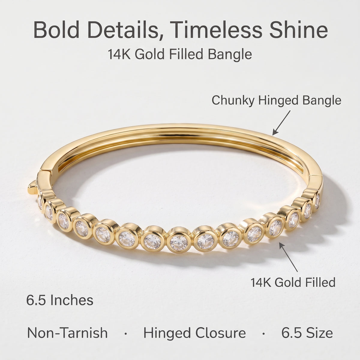 A 14K gold-filled chunky hinged bangle bracelet with a row of round clear stones, shown on a light gray background with text labels and feature callouts.