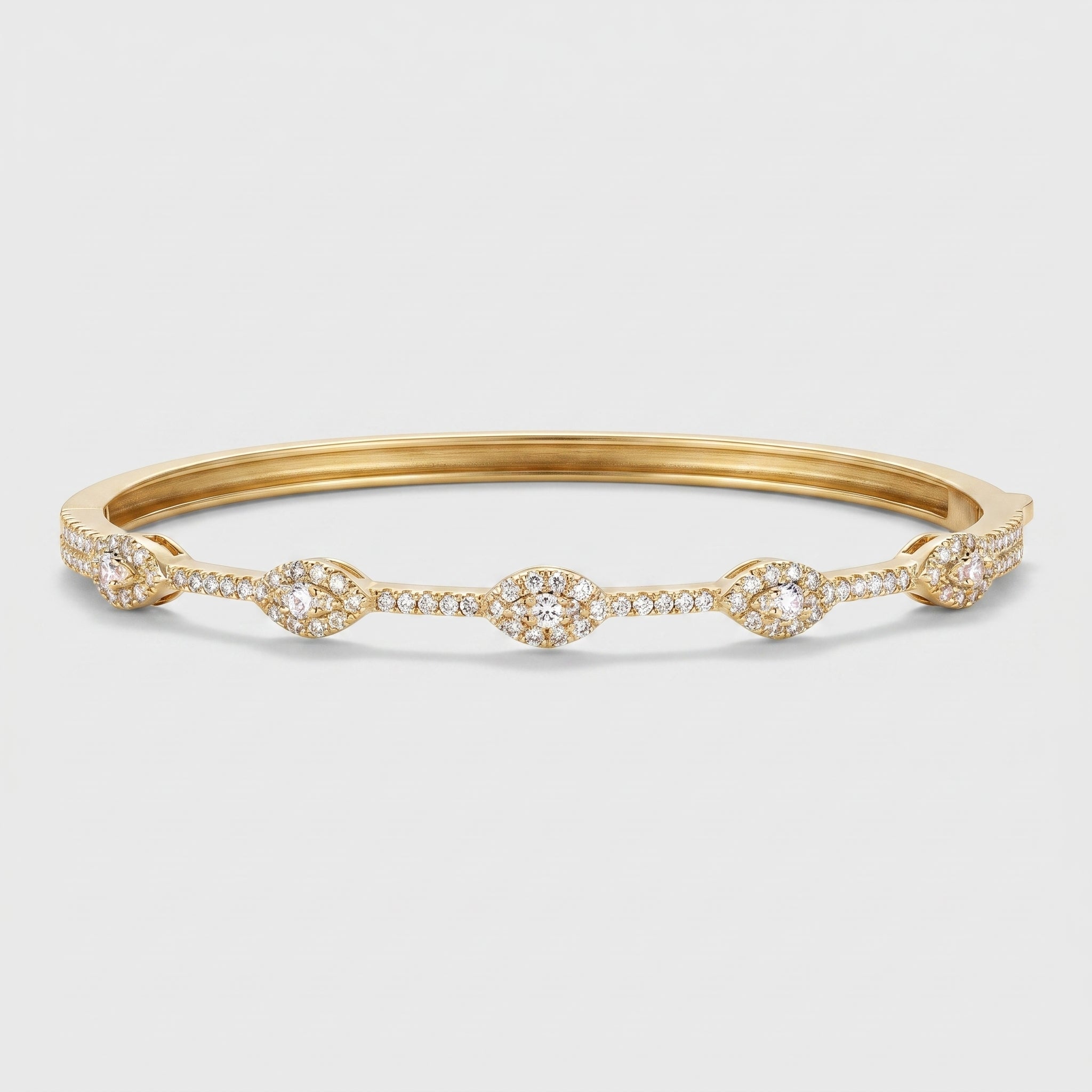 A gold bangle bracelet featuring five ornate marquise-shaped clusters of small clear pavé stones, set against a light gray background.