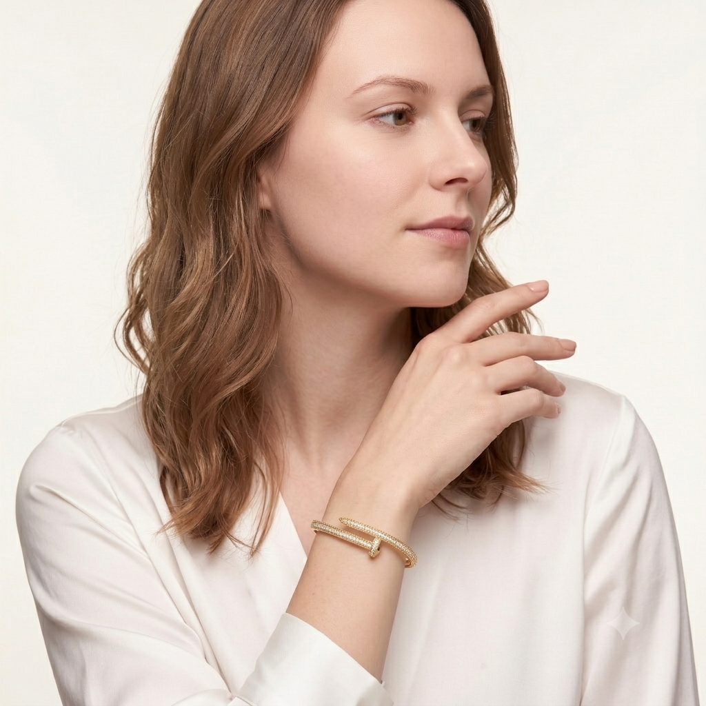 Woman in a cream blouse wearing the MH Elegance 14K gold plated nail bracelet with a row of pave stones