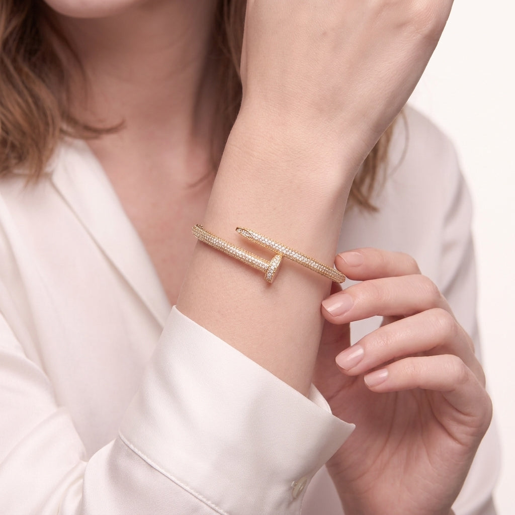 Detail of the gold plated nail bracelet showing the nail head end and the pave stone row on the wrist