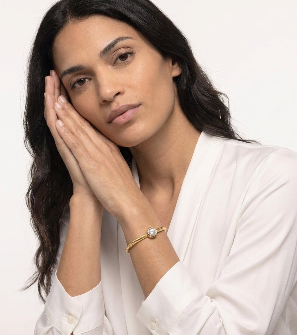 Woman in a white blouse wearing the MH Elegance 18K gold plated twisted rope bracelet with a round cubic zirconia stone