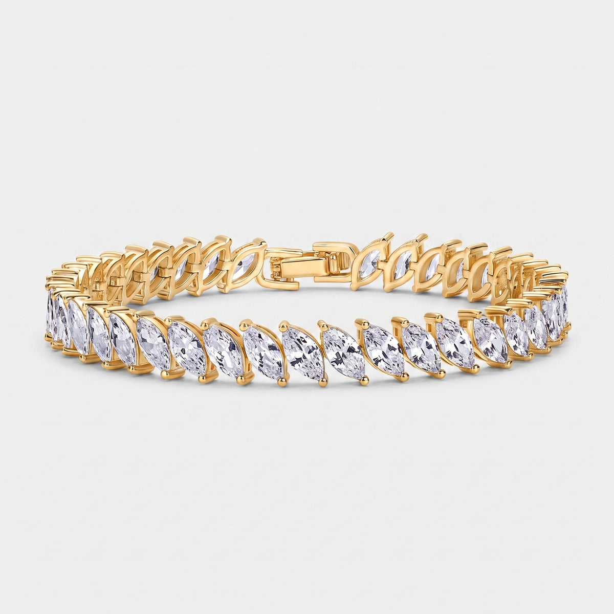 A gold tennis bracelet featuring a row of marquise-cut clear gemstones in a prong setting, displayed on a light gray background.