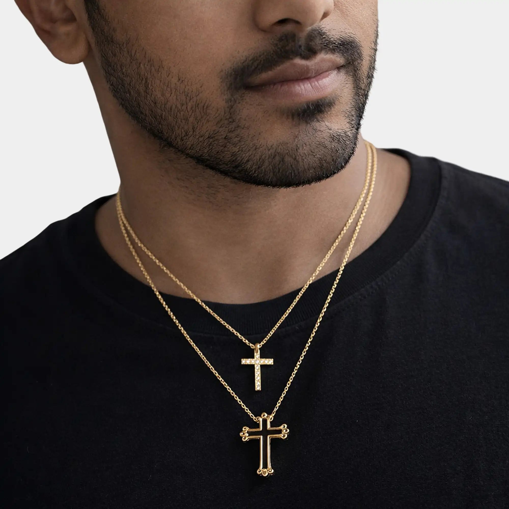 Couple wearing matching 14K gold plated puzzle cross necklace set lifestyle photo.