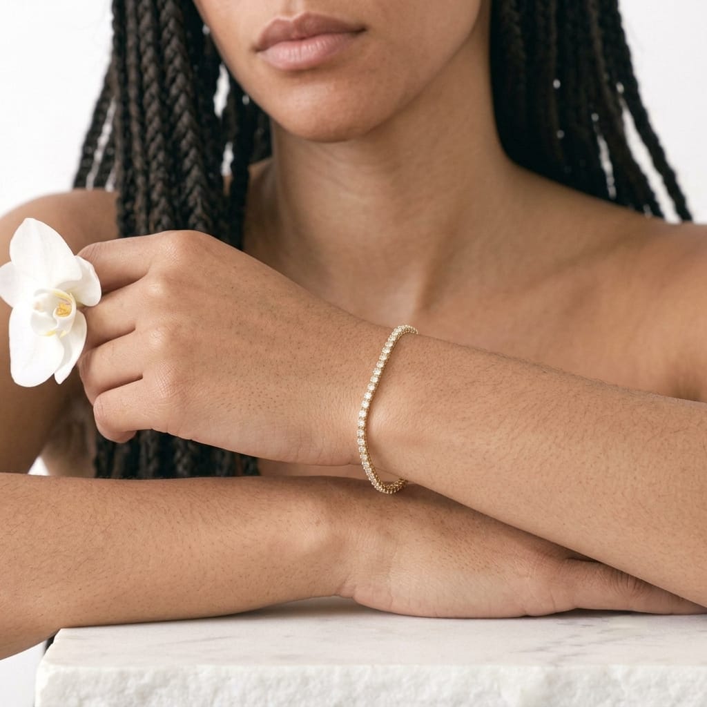 Close view of a 14K gold filled cubic zirconia tennis bracelet resting on a marble ledge