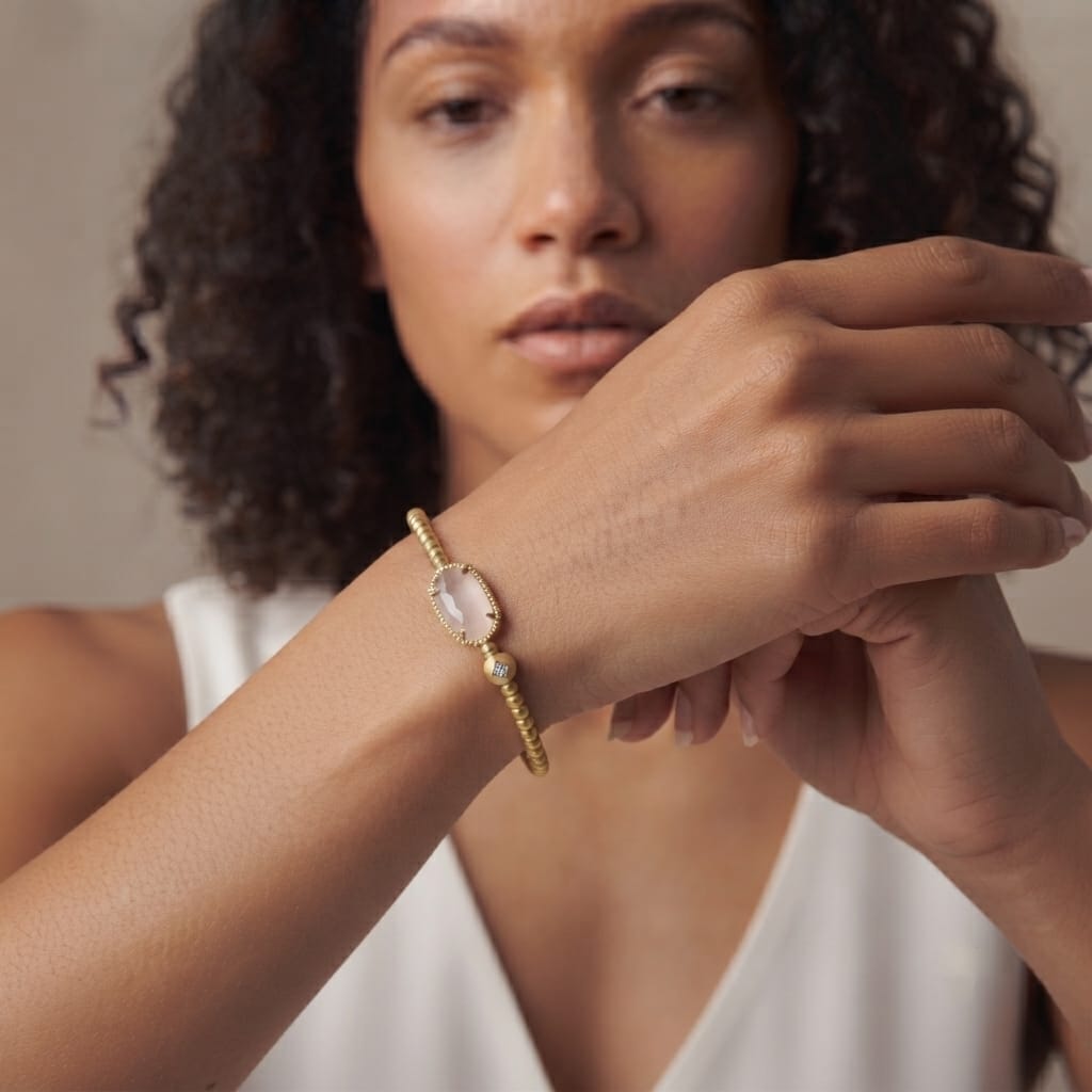 Woman wearing a no clasp rose quartz stretch bracelet on her wrist