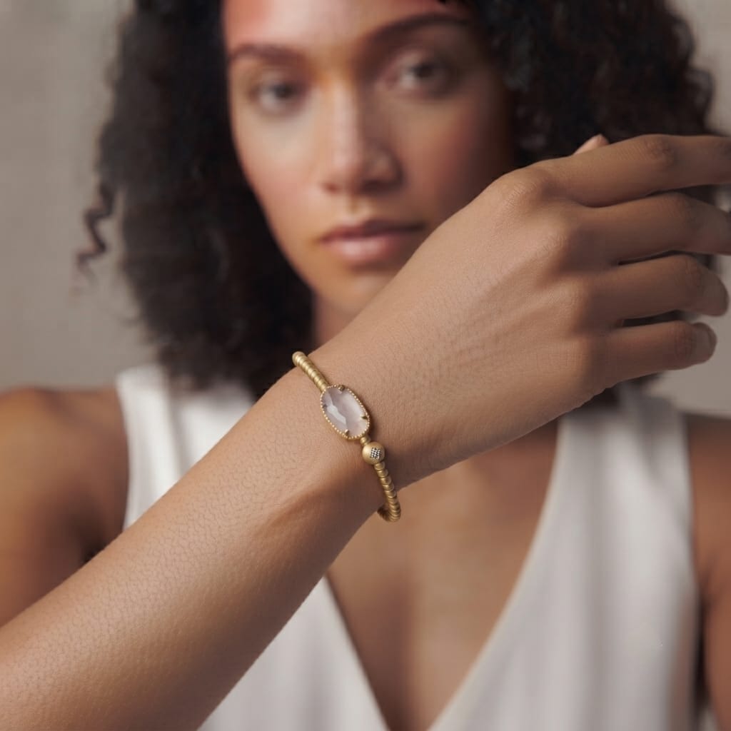 One size rose quartz gold stretch bracelet styled with a white top