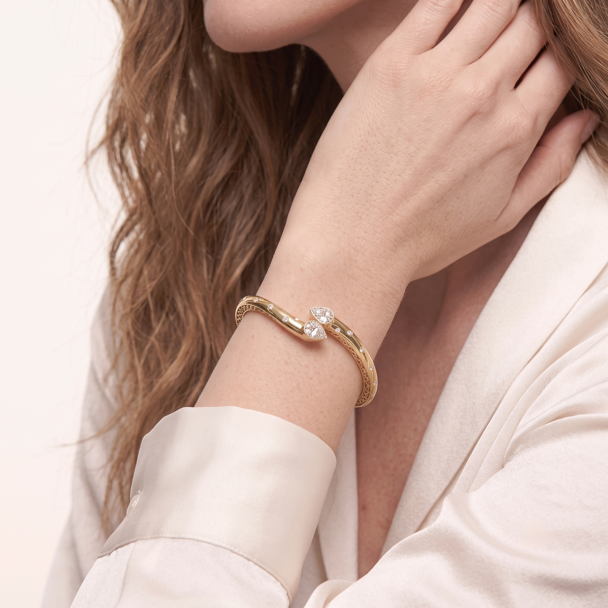 Close-up of the two pear-shaped cubic zirconia stones on the gold cuff bangle bracelet on a wrist