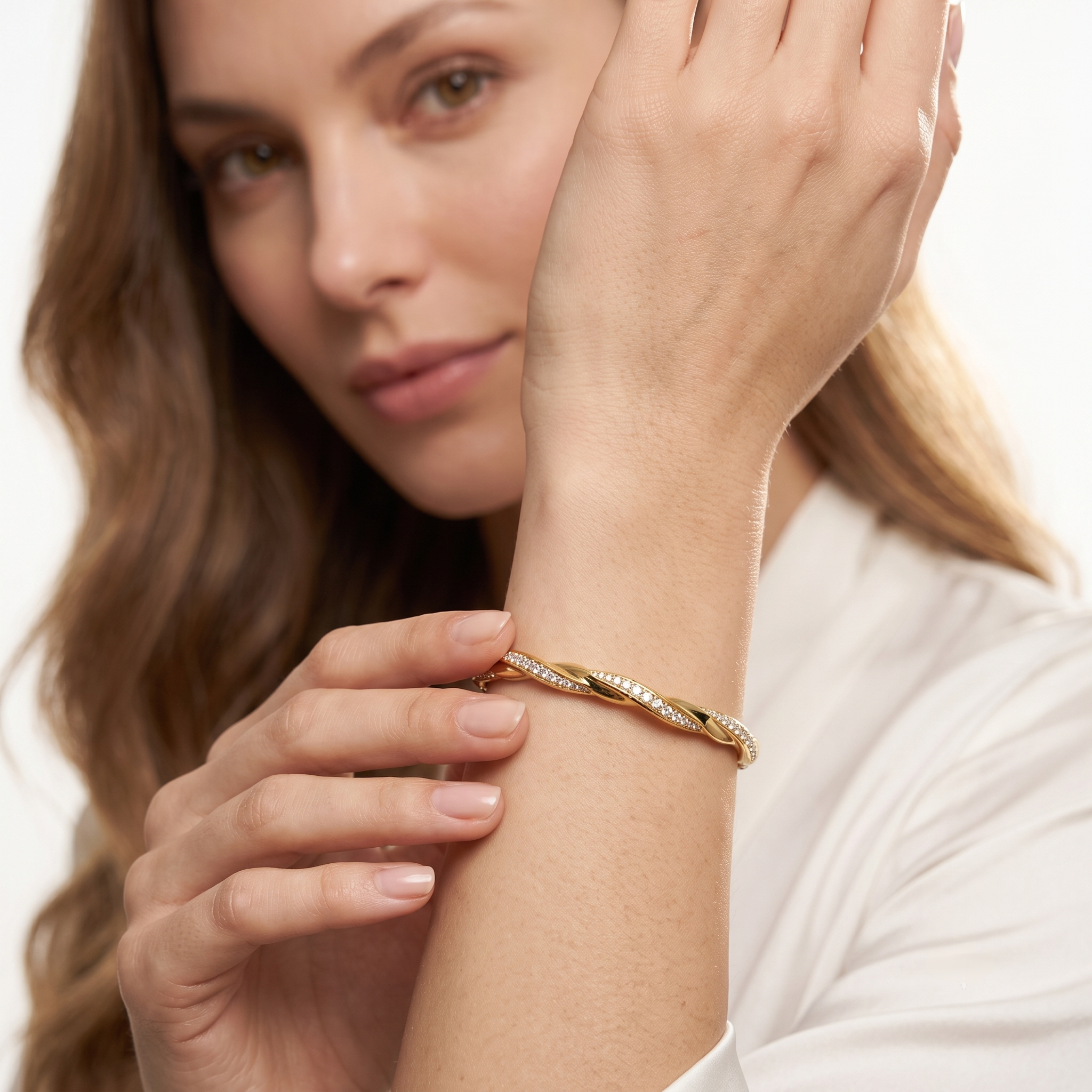 Close-up of the twisted gold bangle with a row of moissanite stones on a wrist