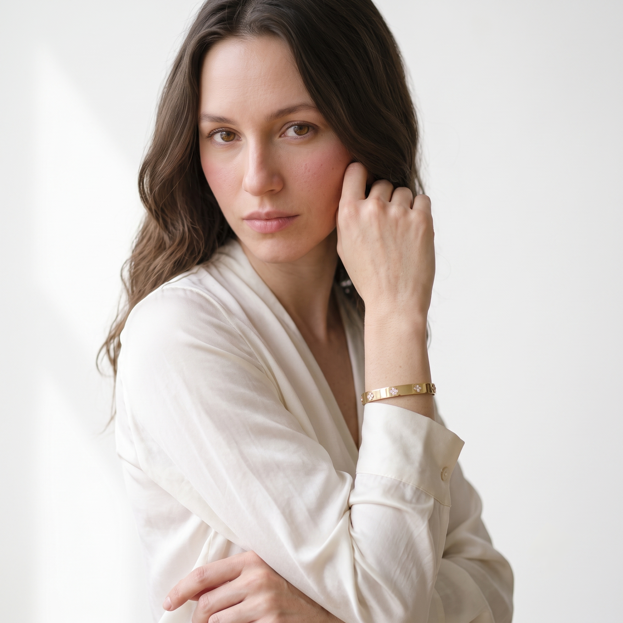 MH Elegance gold plated clover bracelet styled with a cream blouse for work or evening