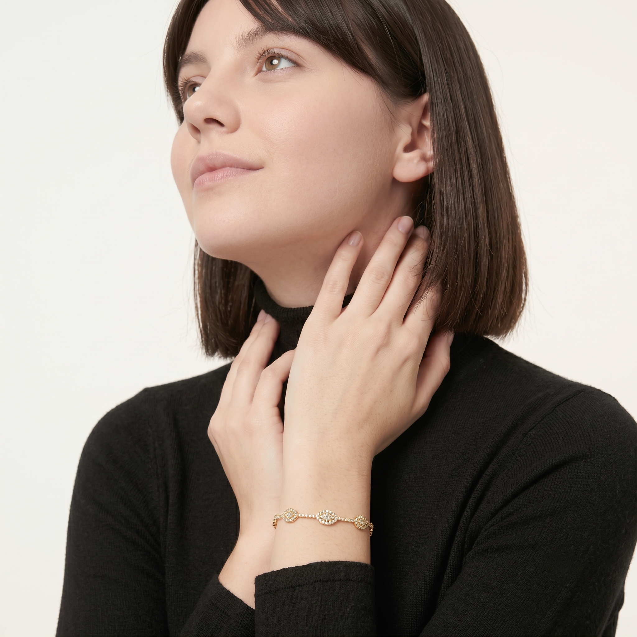 Woman touching her neck while wearing the evil eye bangle bracelet with sparkling cubic zirconia clusters