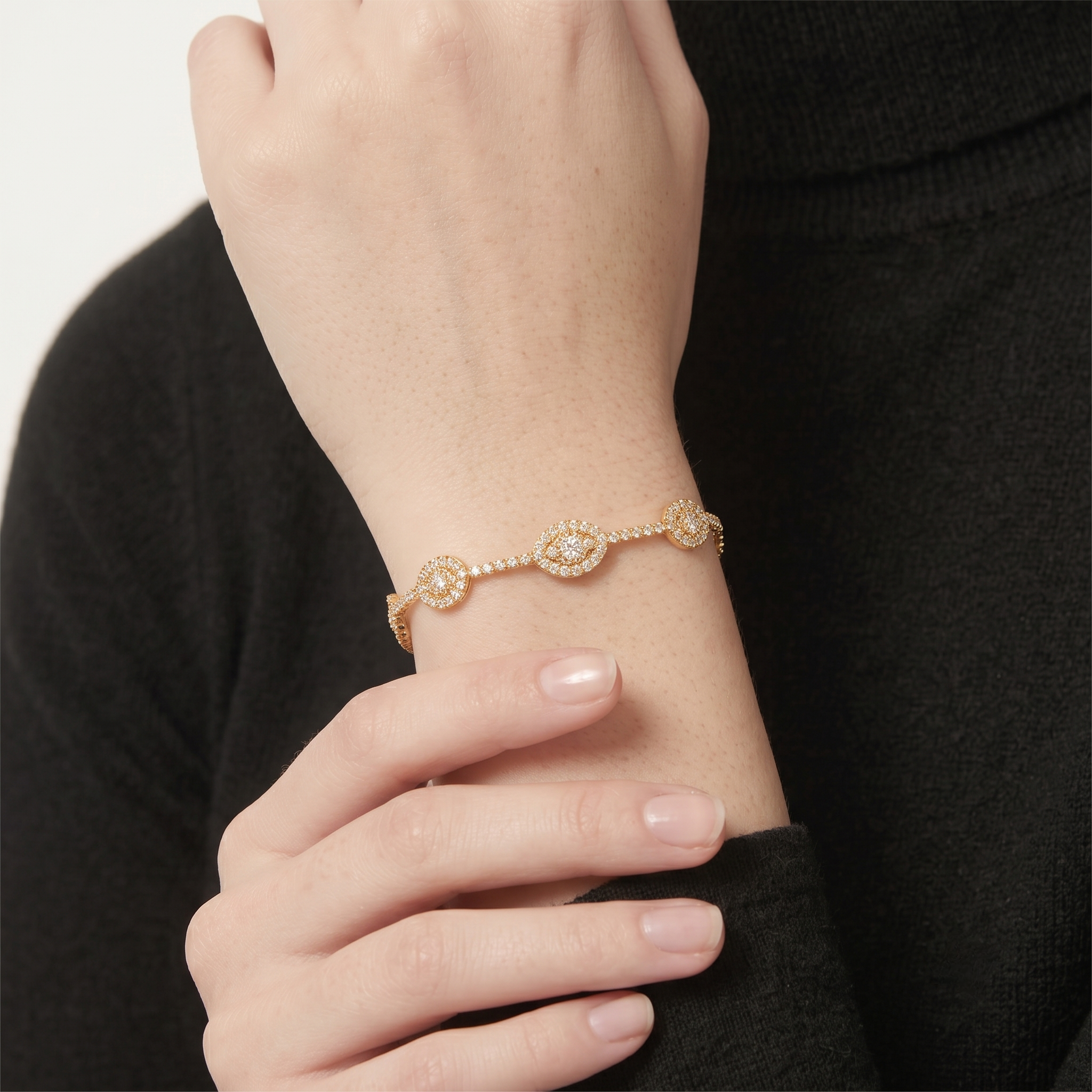 Close-up of the 14K gold filled evil eye bangle bracelet with pave cubic zirconia clusters on the wrist