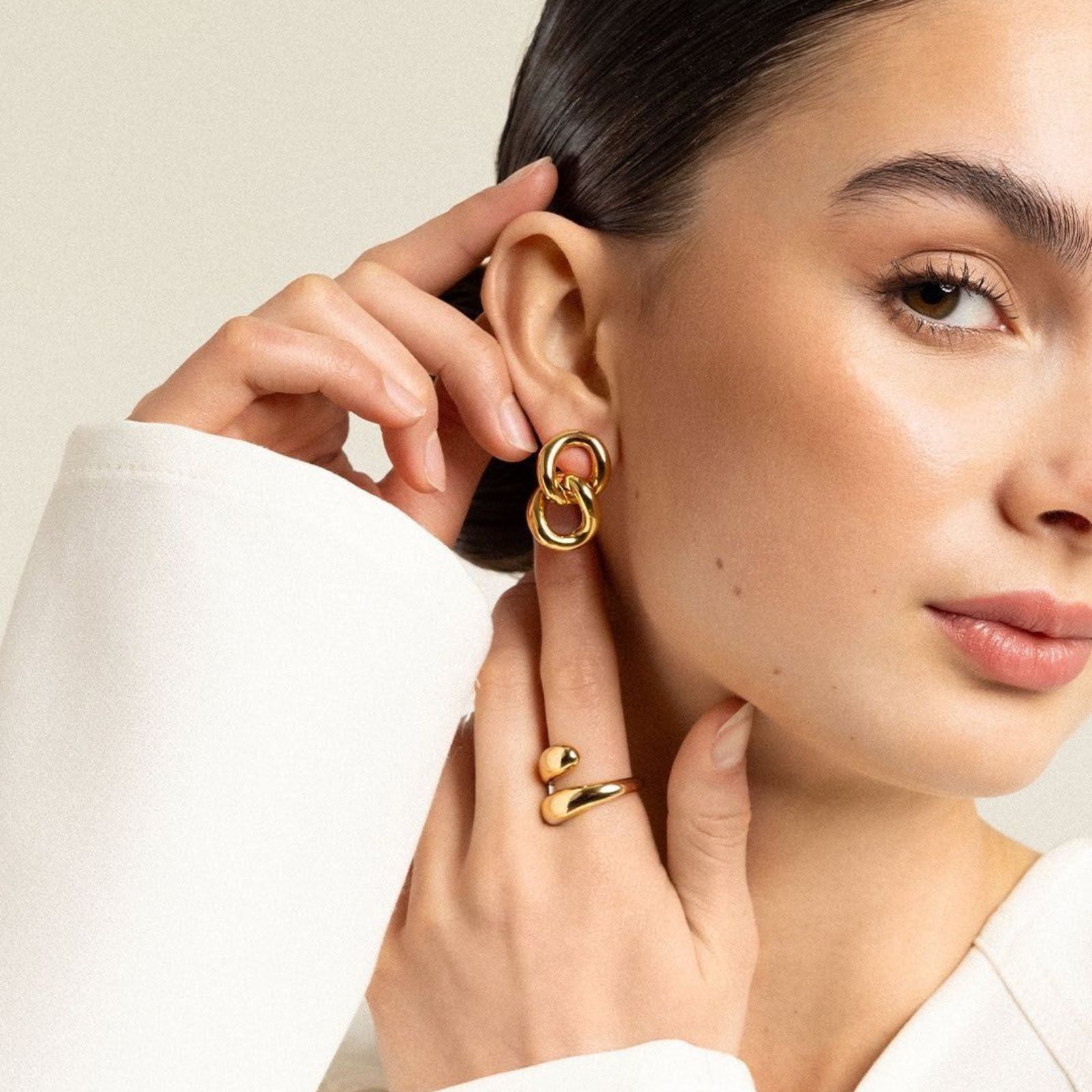 Woman wearing MH Elegance gold earring and ring — the elegance and care behind every piece we create