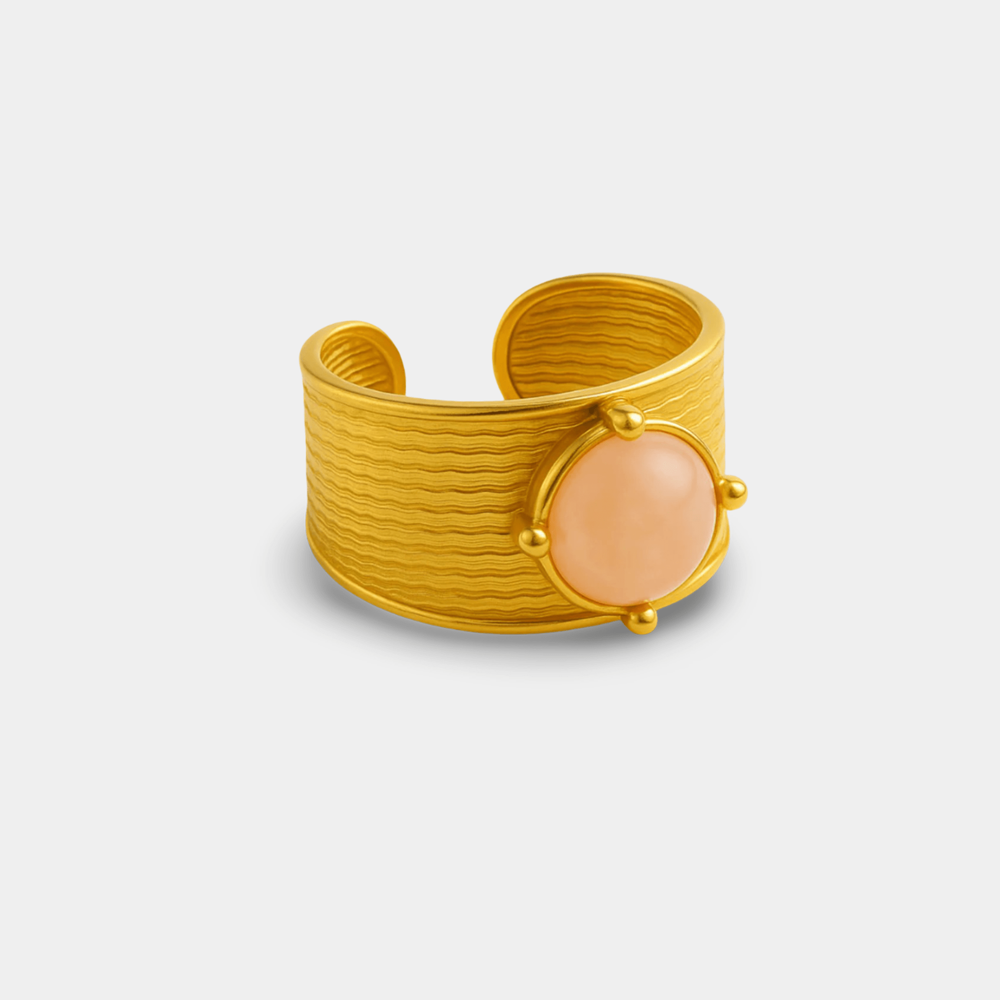 Dynasty gemstone cuff ring in 18K gold plated stainless steel with a round blush cabochon stone, angled view