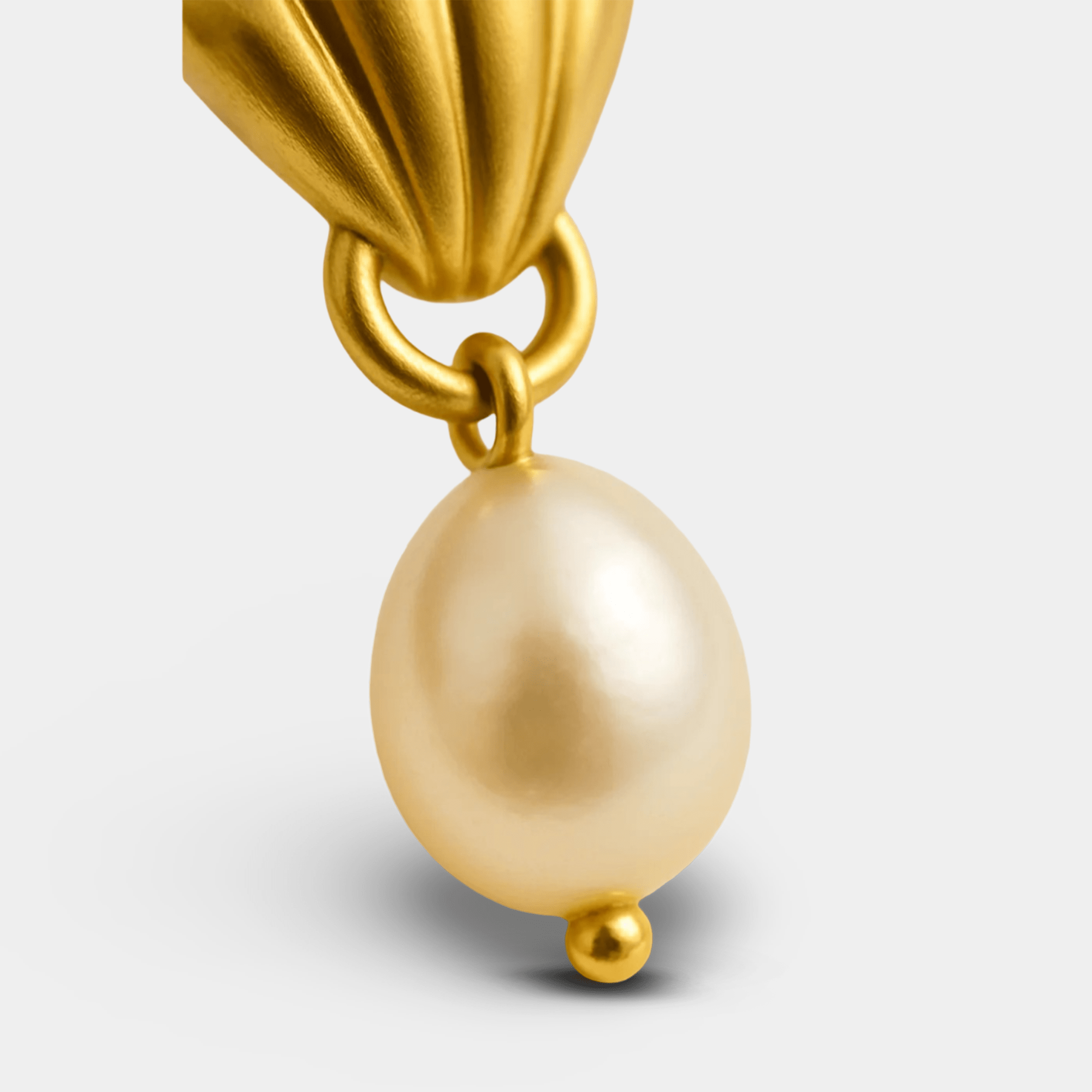 Model wearing Glam Shell gold drop earrings showing drop length and gentle movement