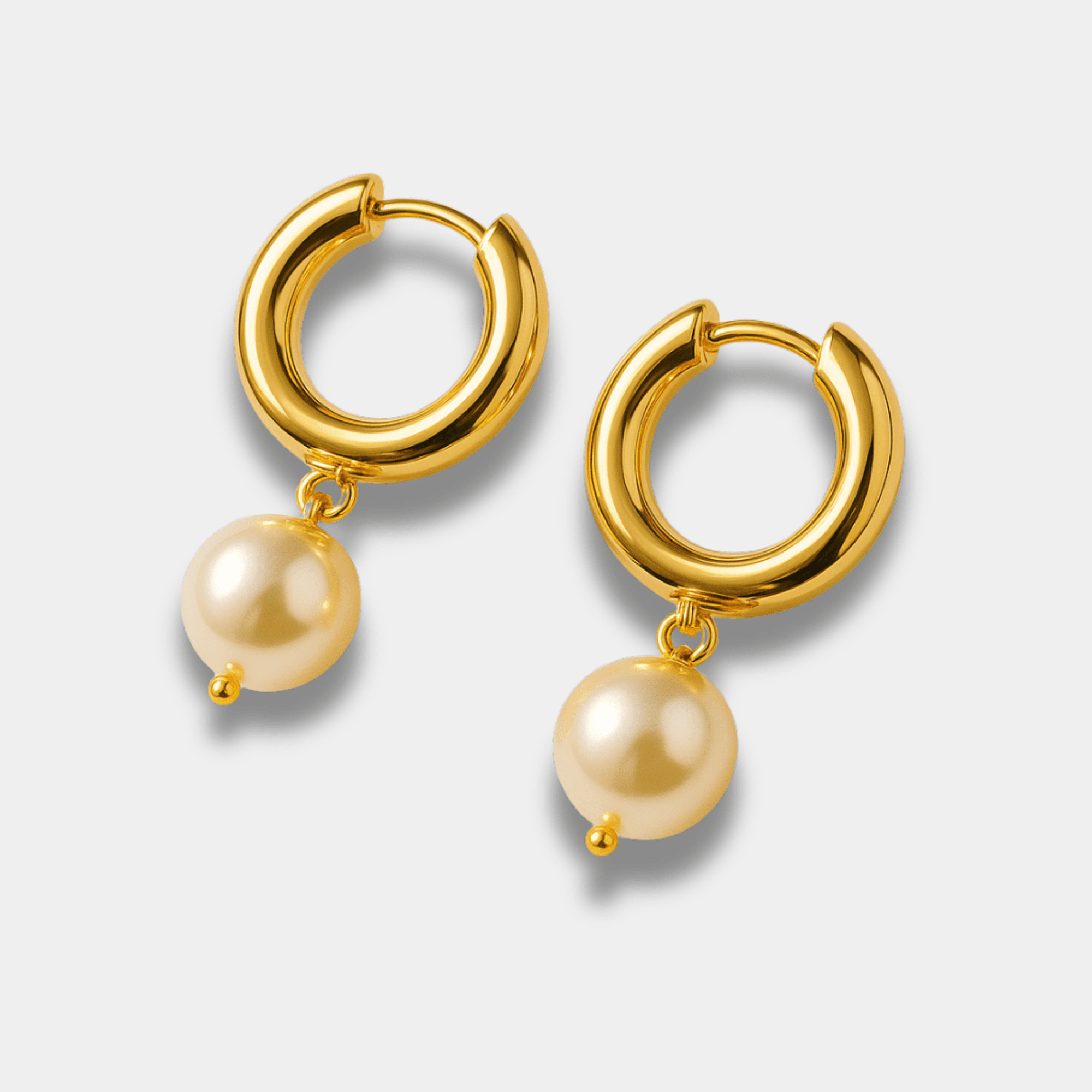 Pair of Goldie Pearl gold hoop earrings shown together with matching freshwater pearl placement