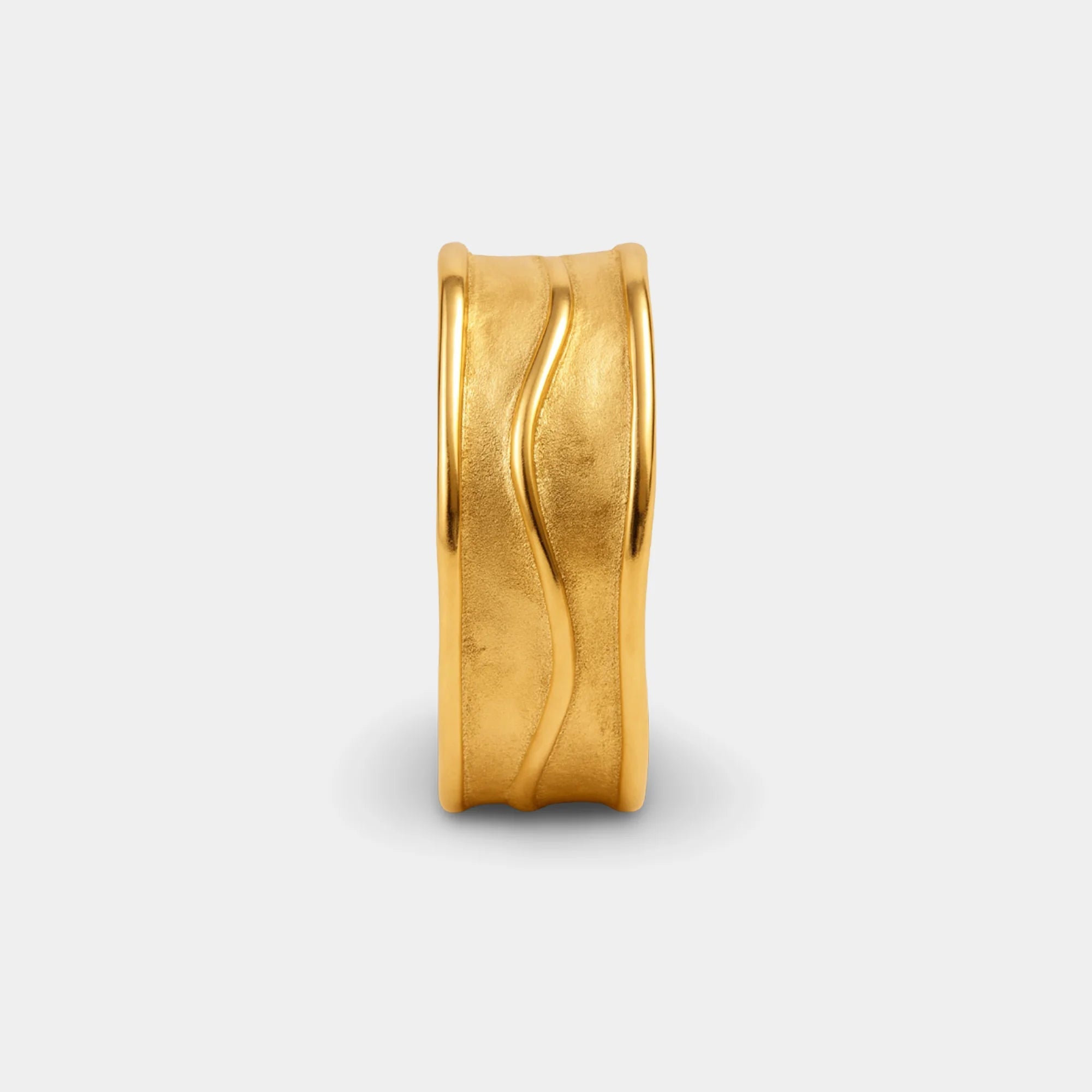 Gold hammered ring worn alone on the finger for a bold, sculptural look