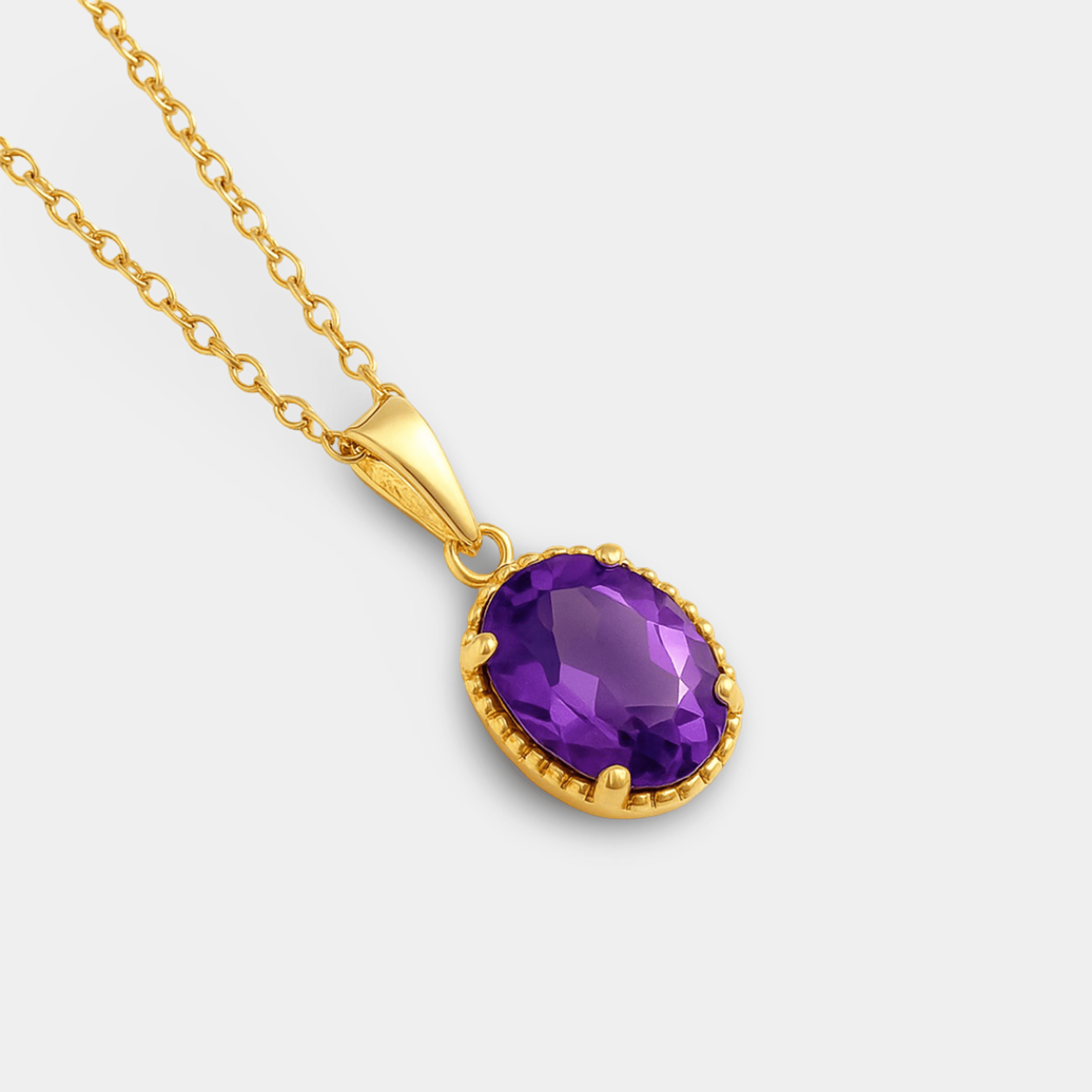 Angled view of the oval amethyst pendant with a beaded gold frame and gold bail
