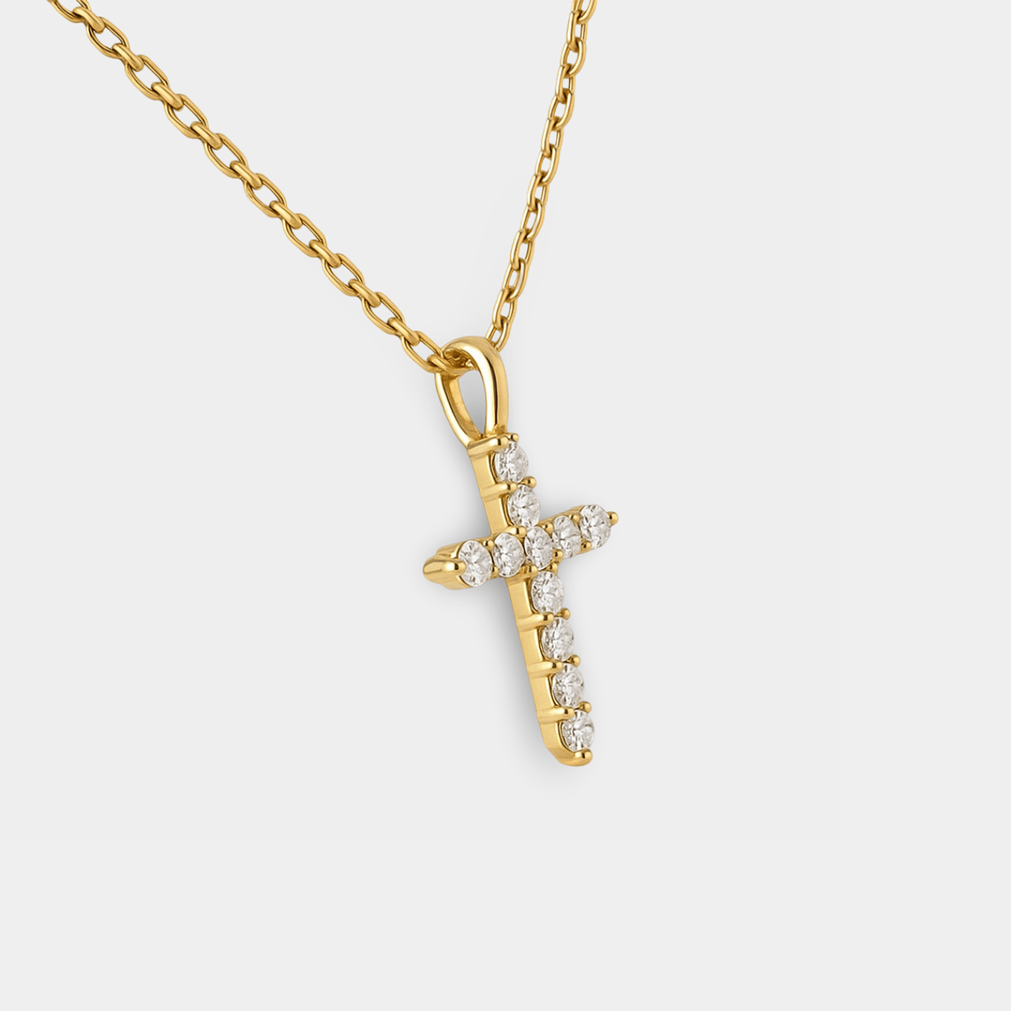 Lunara CZ cross necklace worn around a woman's neck showing the gold cross pendant and adjustable chain