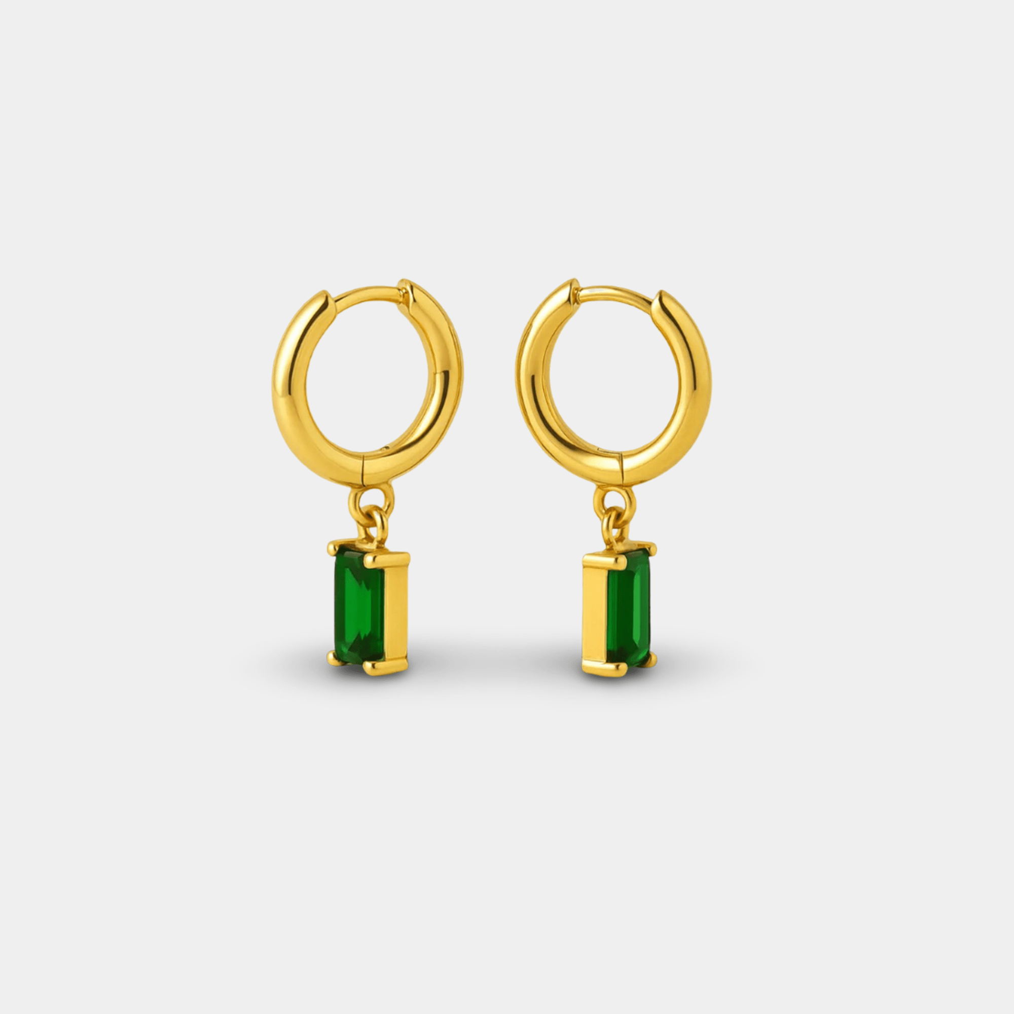 Emerald green hoop earrings worn on a woman's ear