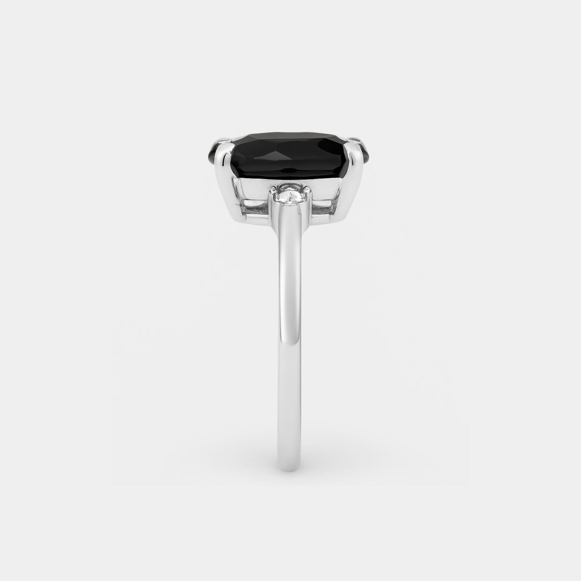 Onyx three-stone ring shown from the side on a sterling silver band.