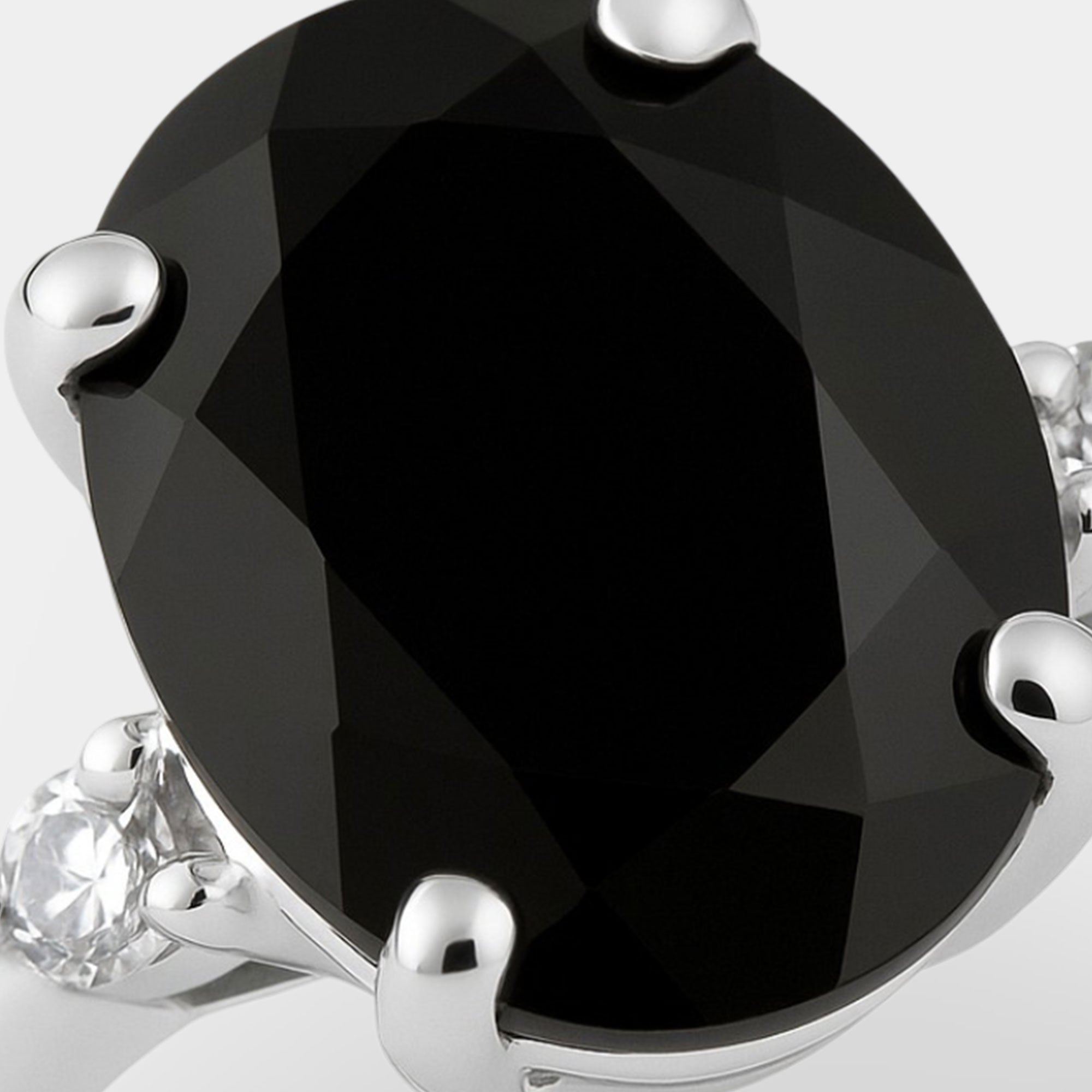 Black onyx and diamond ring displayed at an angle to show the sterling silver band.