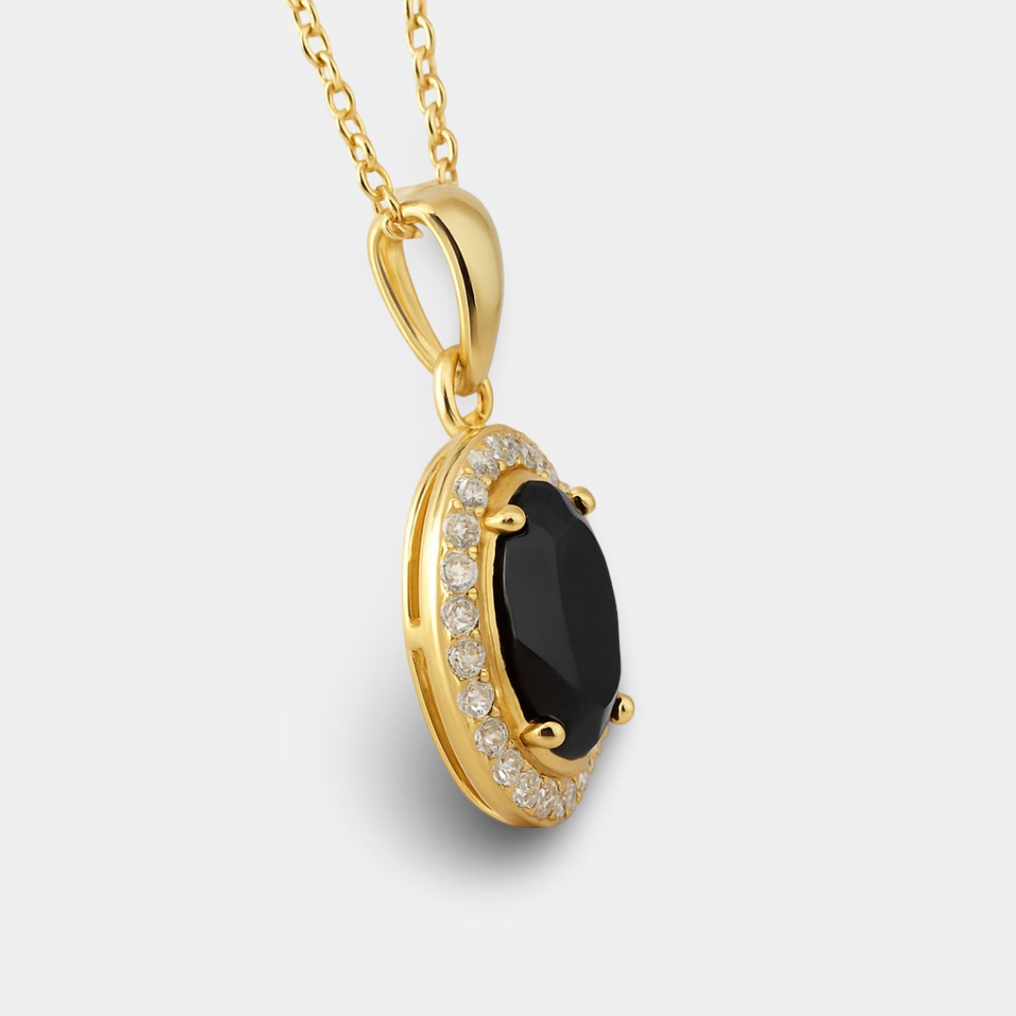 Oval black onyx pendant shown at an angle to show the gold-plated halo.