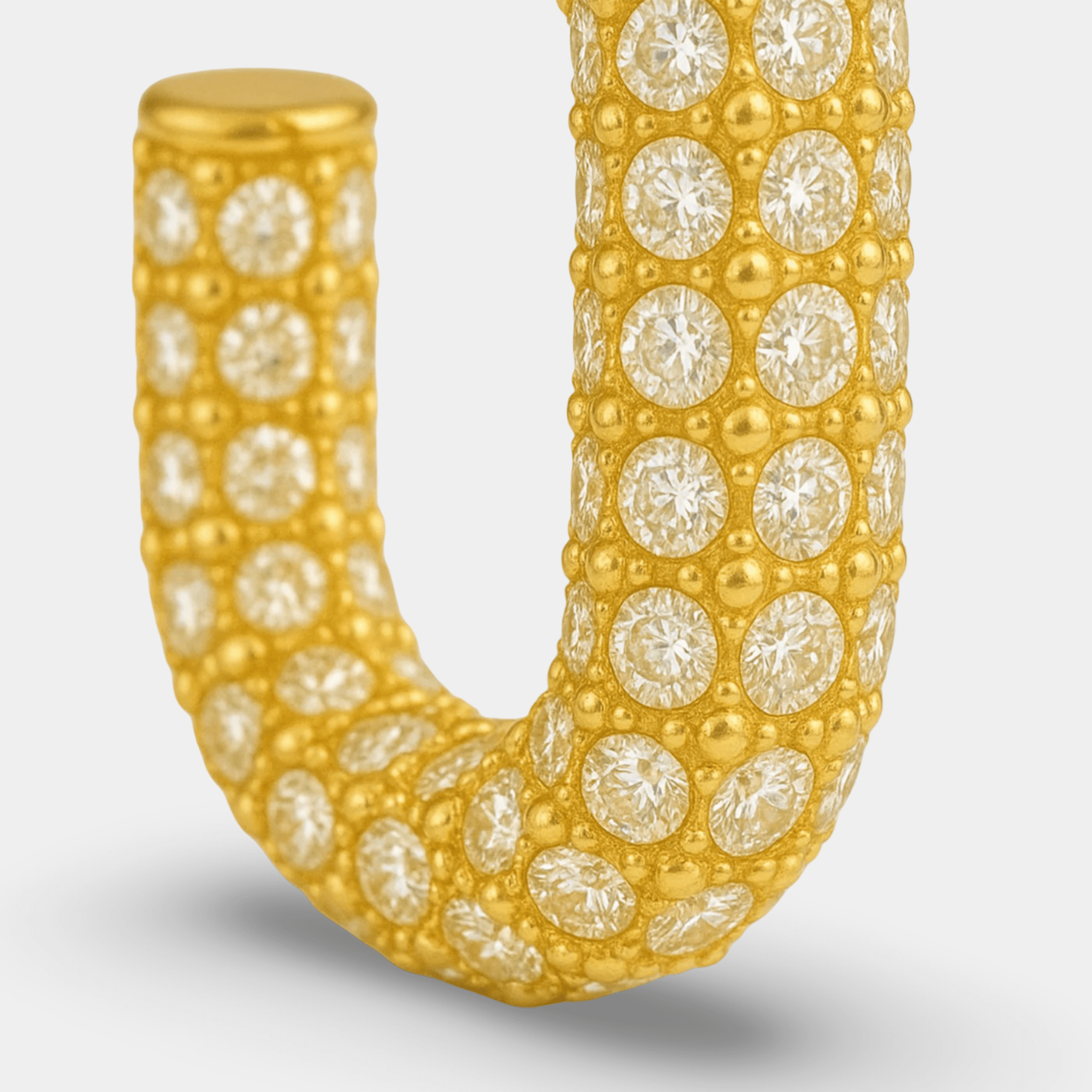 Side view of the sparkly gold hoop earring showing its secure closure