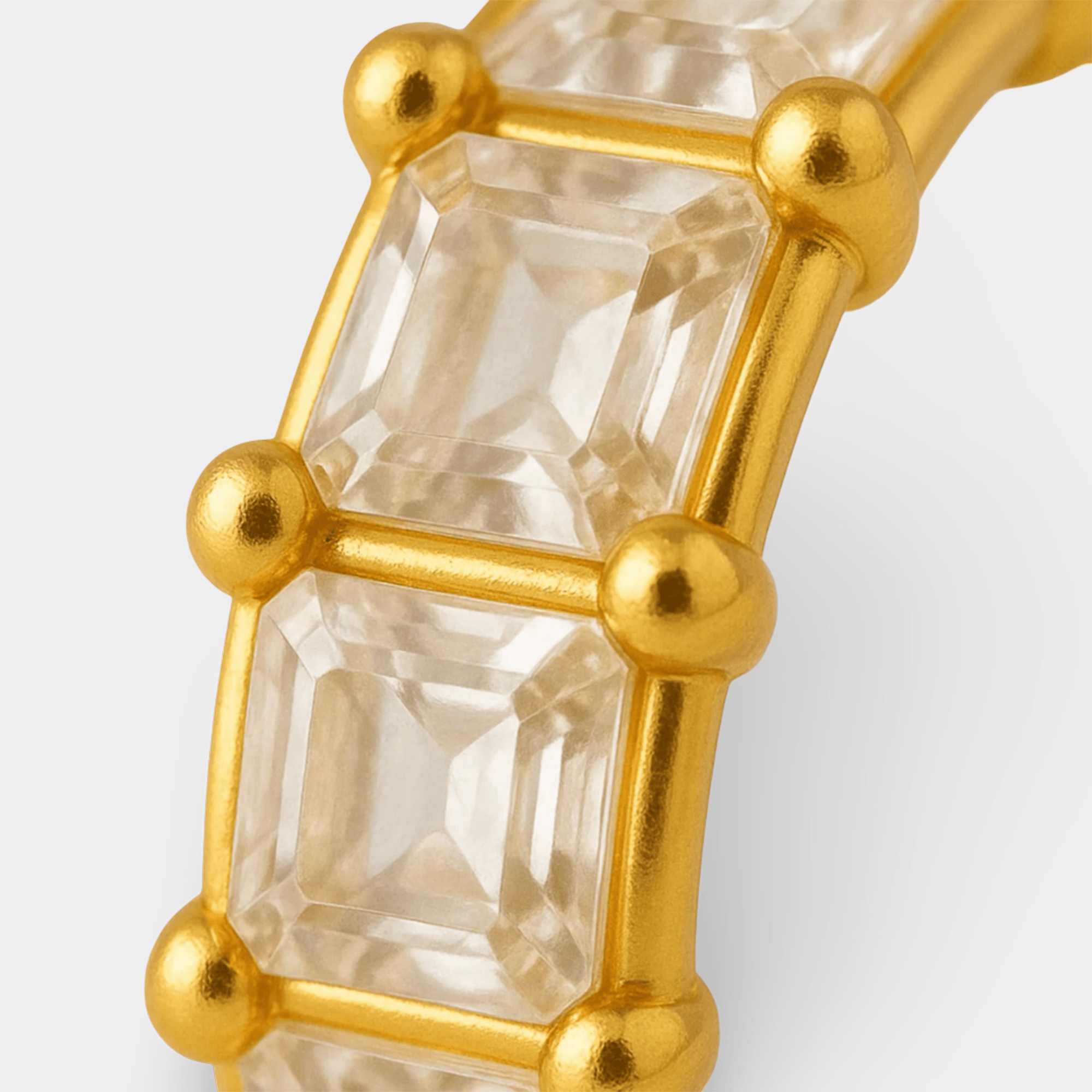 Prism crown hoop earrings displayed on a jewelry tray showing the polished 18K gold-plated finish