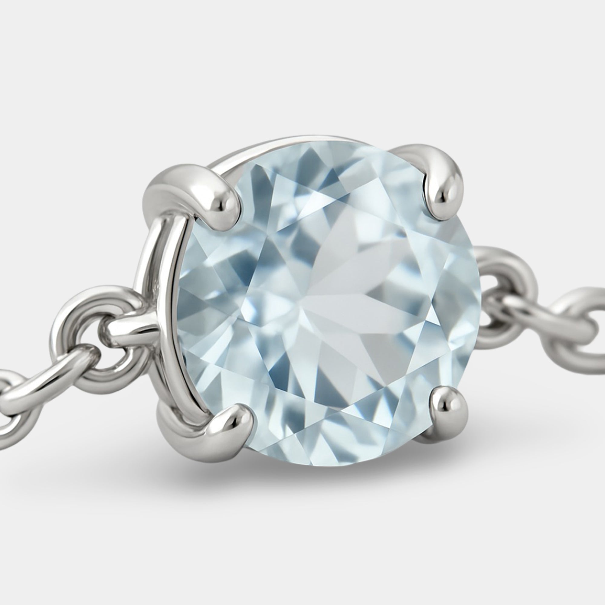 Macro close-up of the sky blue aquamarine held by four silver prongs on the bolo bracelet chain