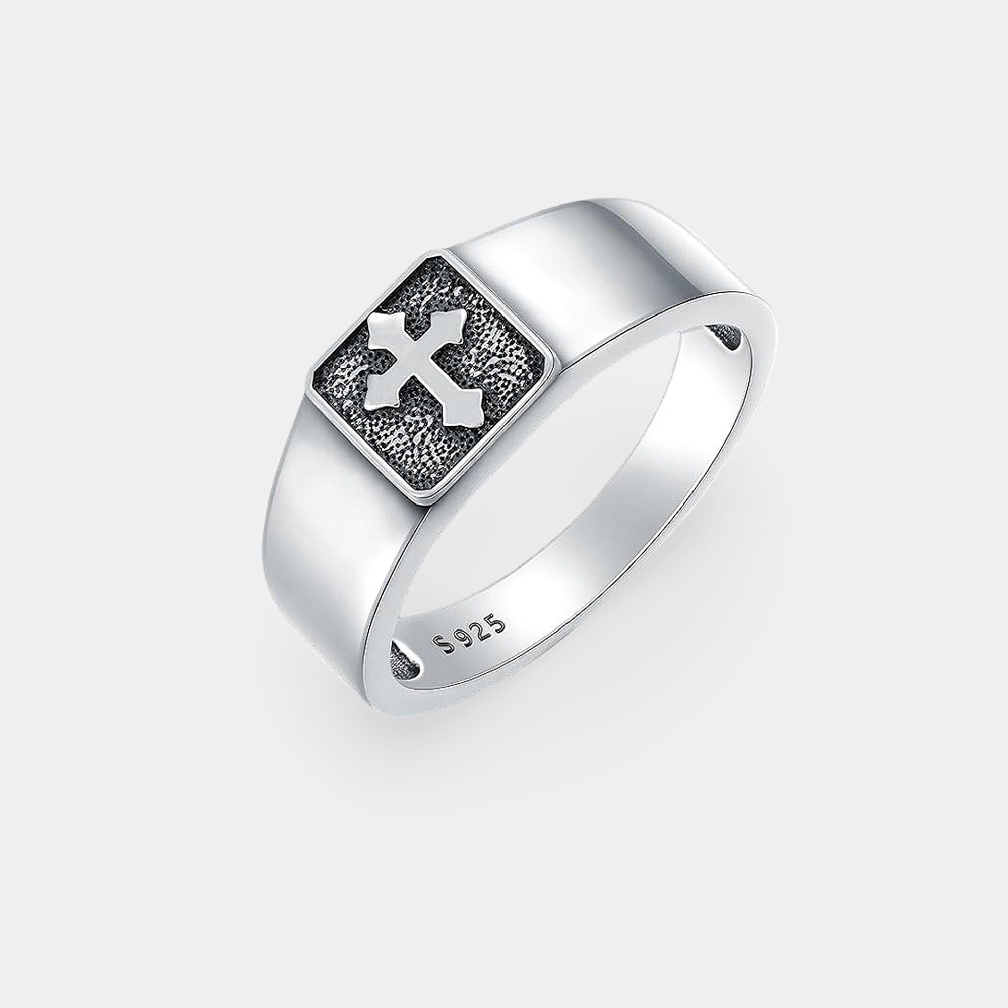 Close-up of the engraved cross on a silver signet ring